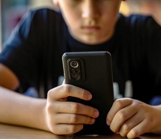 Kolik času by měly děti trávit u obrazovek? Existuje vůbec vhodná míra? Kluk s telefonem v ruce